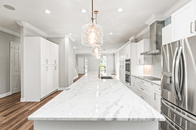 kitchen with wall chimney exhaust hood, stainless steel appliances, sink, hanging light fixtures, and a large island