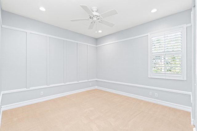 carpeted spare room featuring ceiling fan