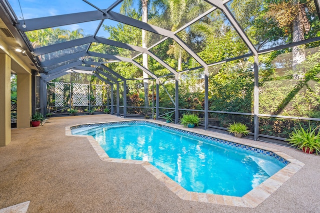 view of pool with a patio and glass enclosure