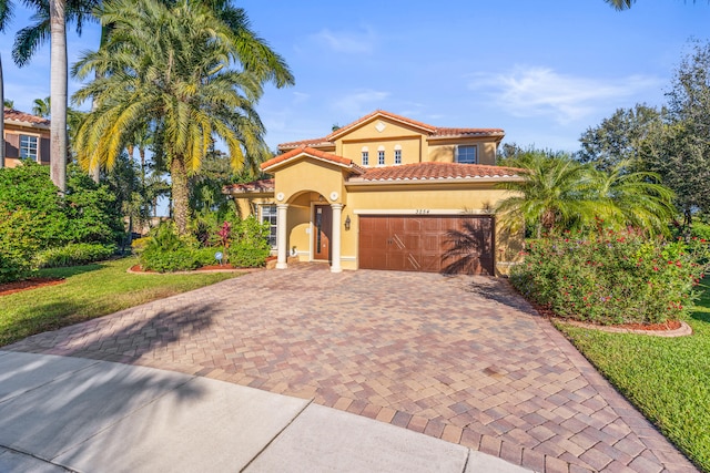 mediterranean / spanish-style house with a garage and a front lawn