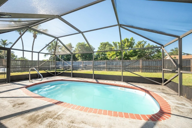 view of pool with glass enclosure and a patio area