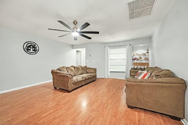 living room with a ceiling fan, light wood-type flooring, visible vents, and baseboards