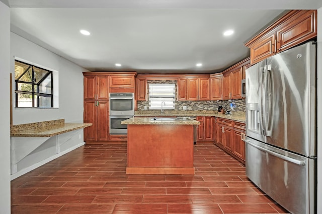 kitchen featuring appliances with stainless steel finishes, a kitchen island, decorative backsplash, and wood tiled floor