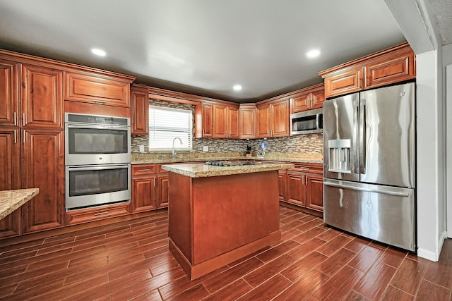 kitchen with tasteful backsplash, brown cabinetry, wood tiled floor, and stainless steel appliances