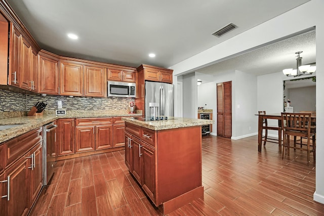 kitchen featuring visible vents, appliances with stainless steel finishes, dark wood finished floors, and backsplash