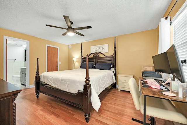 bedroom with a textured ceiling, ensuite bath, a ceiling fan, and light wood-style floors