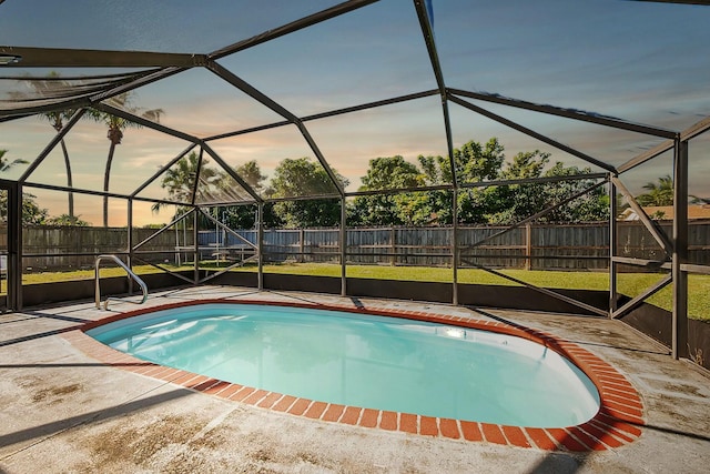 pool at dusk featuring a patio area, a fenced backyard, and a yard