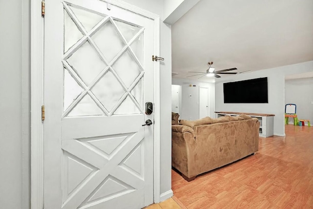 living room with a ceiling fan and light wood-style flooring