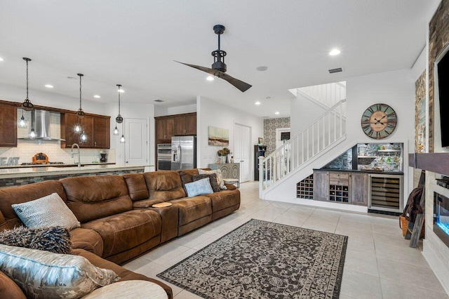 living room featuring sink, light tile patterned floors, and ceiling fan