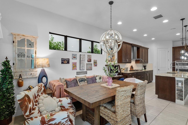 tiled dining area with wine cooler, a notable chandelier, and sink