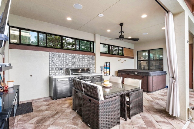 view of patio featuring ceiling fan, a hot tub, and exterior kitchen