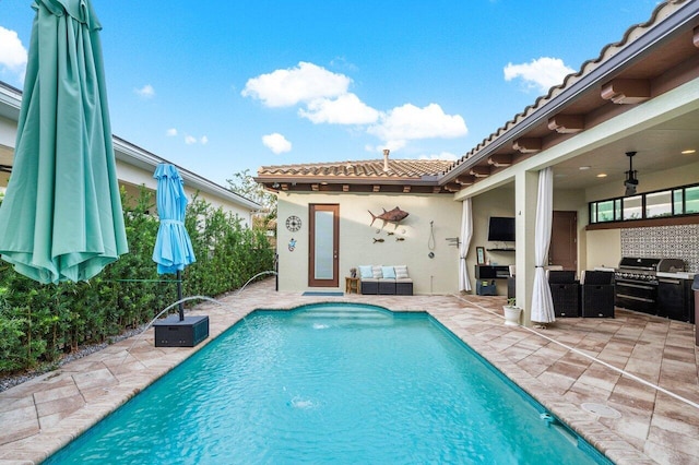 view of pool with pool water feature, grilling area, and a patio area