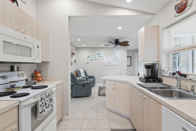 kitchen featuring white appliances, sink, light brown cabinetry, and vaulted ceiling