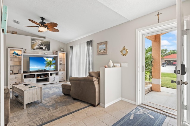 tiled living room with a textured ceiling, ceiling fan, and lofted ceiling