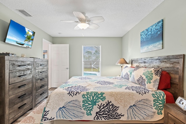 bedroom with ceiling fan and a textured ceiling