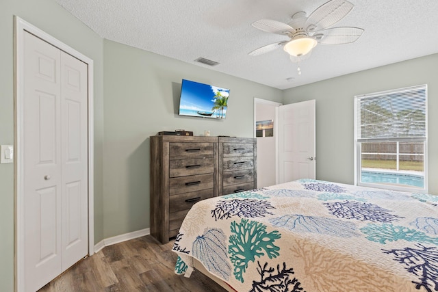 bedroom with hardwood / wood-style floors, ceiling fan, a textured ceiling, and a closet