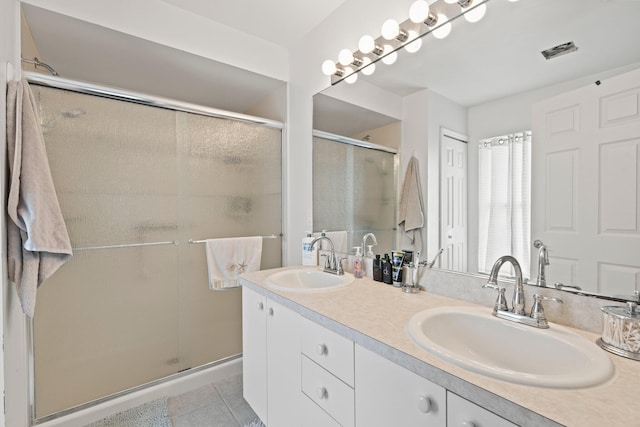 bathroom featuring tile patterned flooring, vanity, and walk in shower