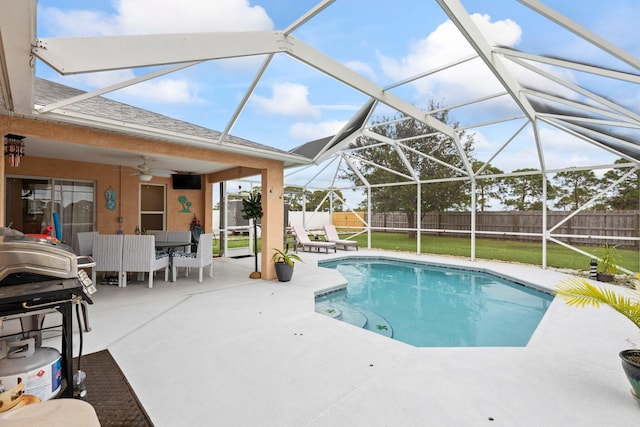 view of swimming pool featuring a lanai, ceiling fan, a patio area, and a yard