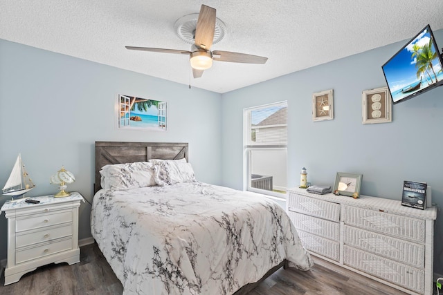 bedroom with ceiling fan, dark hardwood / wood-style flooring, and a textured ceiling