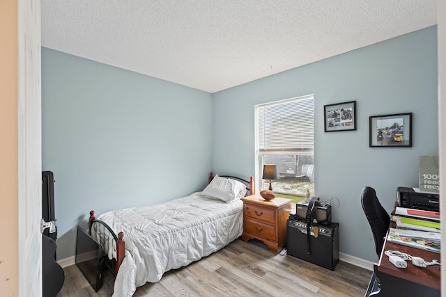 bedroom featuring a textured ceiling and light hardwood / wood-style floors