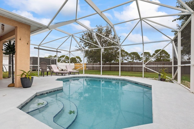 view of pool with a lawn, glass enclosure, and a patio