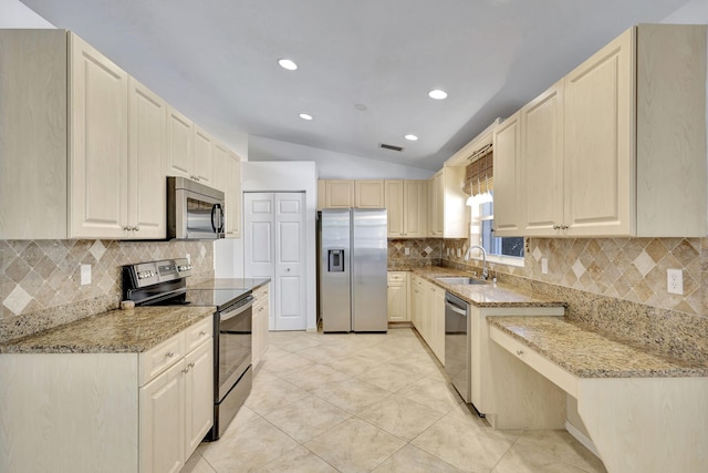 kitchen with light stone countertops, sink, stainless steel appliances, and lofted ceiling