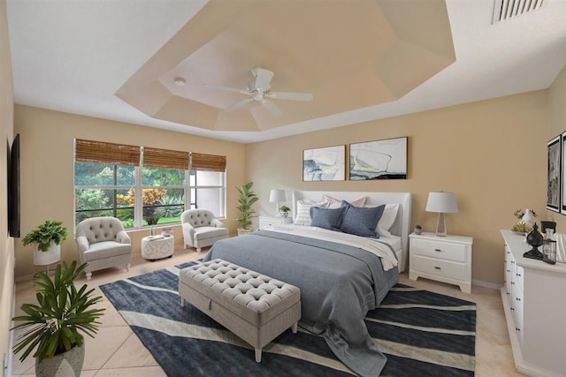 bedroom with a raised ceiling, ceiling fan, and light tile patterned floors