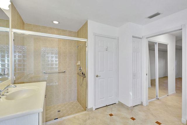 bathroom with tile patterned flooring, vanity, and an enclosed shower