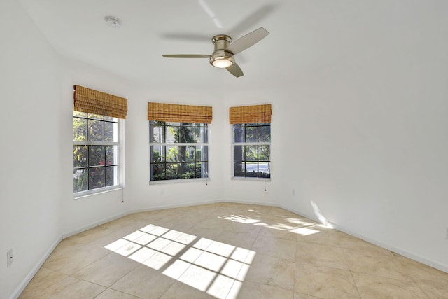 tiled spare room with ceiling fan