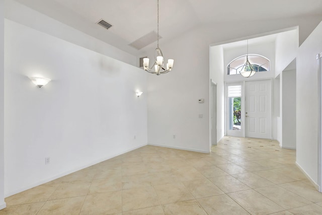 tiled foyer entrance featuring a notable chandelier and vaulted ceiling