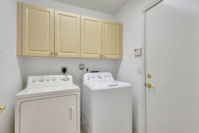 washroom featuring washing machine and clothes dryer and cabinets