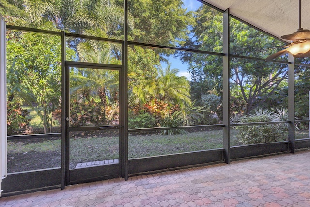 unfurnished sunroom with ceiling fan