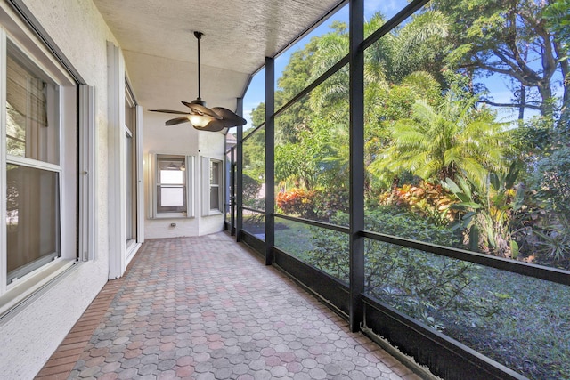 unfurnished sunroom with ceiling fan