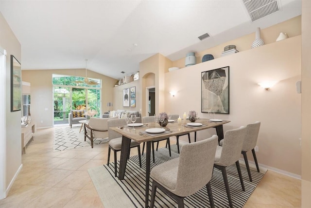 dining area with light tile patterned floors and vaulted ceiling