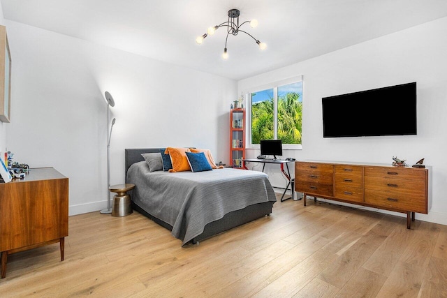 bedroom with a notable chandelier and light hardwood / wood-style flooring