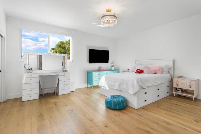 bedroom with light wood-type flooring and a chandelier