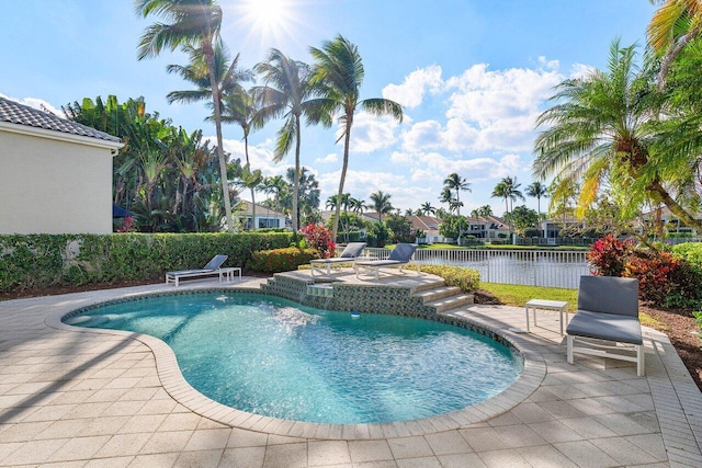 view of swimming pool with a water view and a patio area