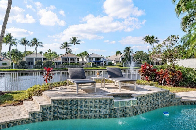 view of pool with an in ground hot tub, pool water feature, and a water view