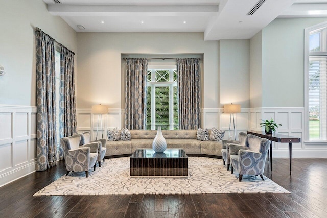 living room featuring hardwood / wood-style floors, plenty of natural light, and beamed ceiling