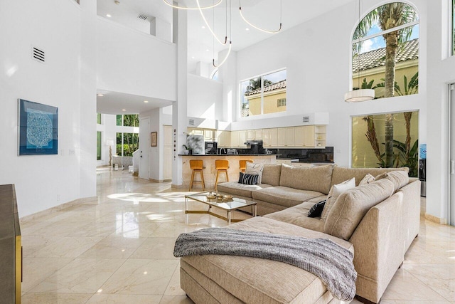 living room with a towering ceiling and a chandelier