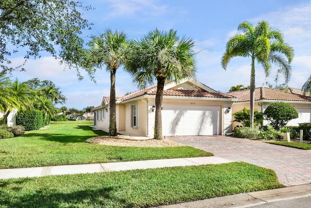 mediterranean / spanish home with a front yard and a garage