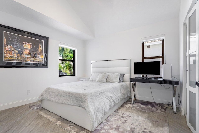 bedroom featuring hardwood / wood-style floors and lofted ceiling