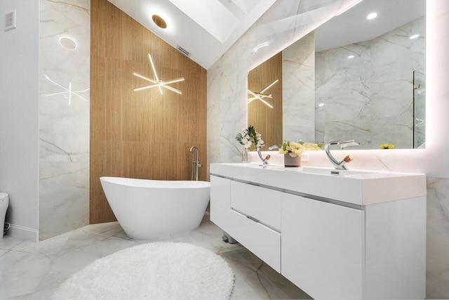 bathroom featuring vanity, a tub to relax in, and tile walls