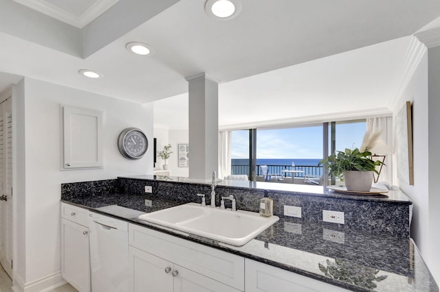 kitchen featuring white cabinetry, dishwasher, sink, dark stone countertops, and a water view