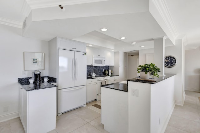 kitchen with white appliances, ornamental molding, kitchen peninsula, and white cabinets