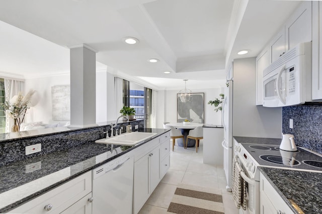 kitchen with sink, white cabinetry, tasteful backsplash, white appliances, and dark stone counters