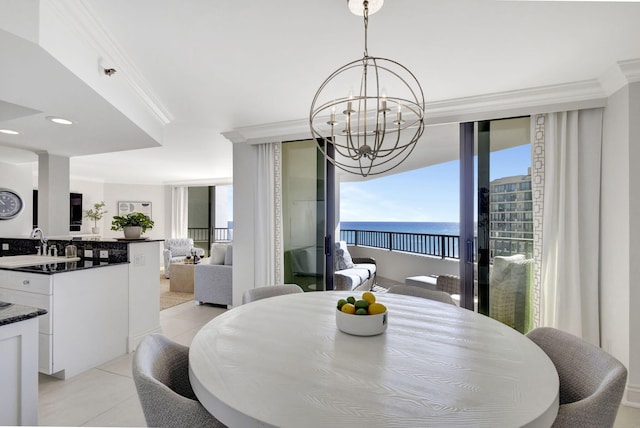 dining room featuring light tile patterned floors, crown molding, sink, a water view, and a chandelier