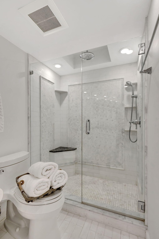 bathroom with toilet and an enclosed shower