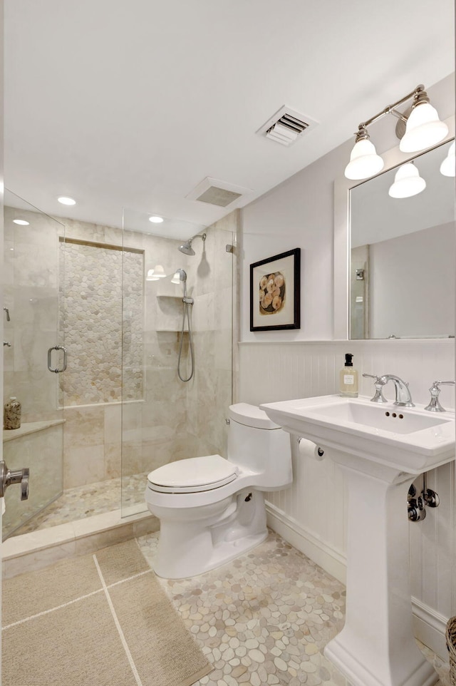 bathroom with a shower with door and toilet