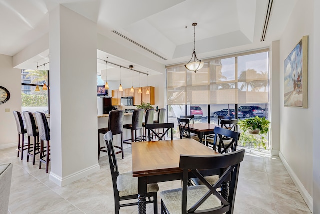 dining area featuring track lighting and a tray ceiling